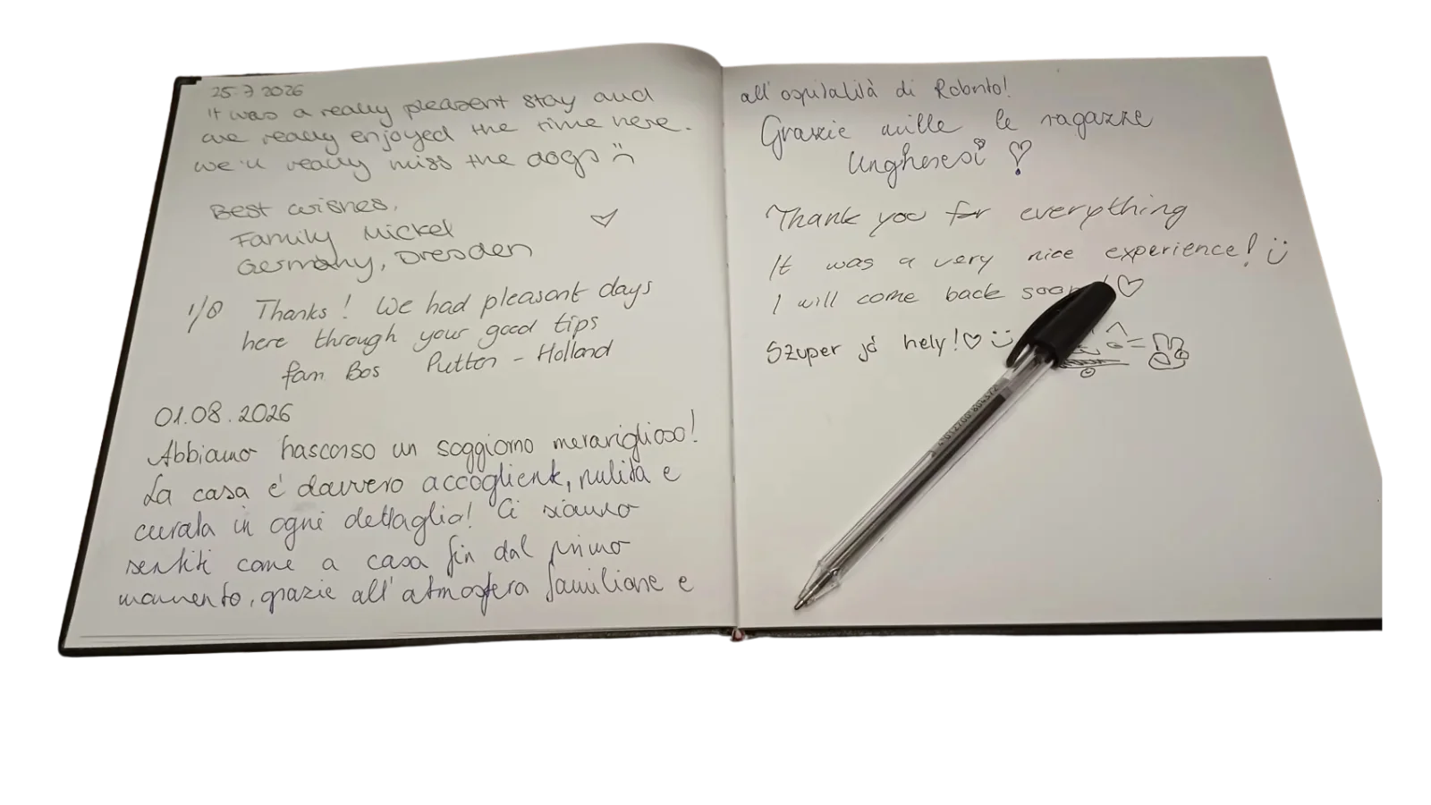 Doppia pagina con i saluti dell'estate 2026 e la penna appoggiata sul libro