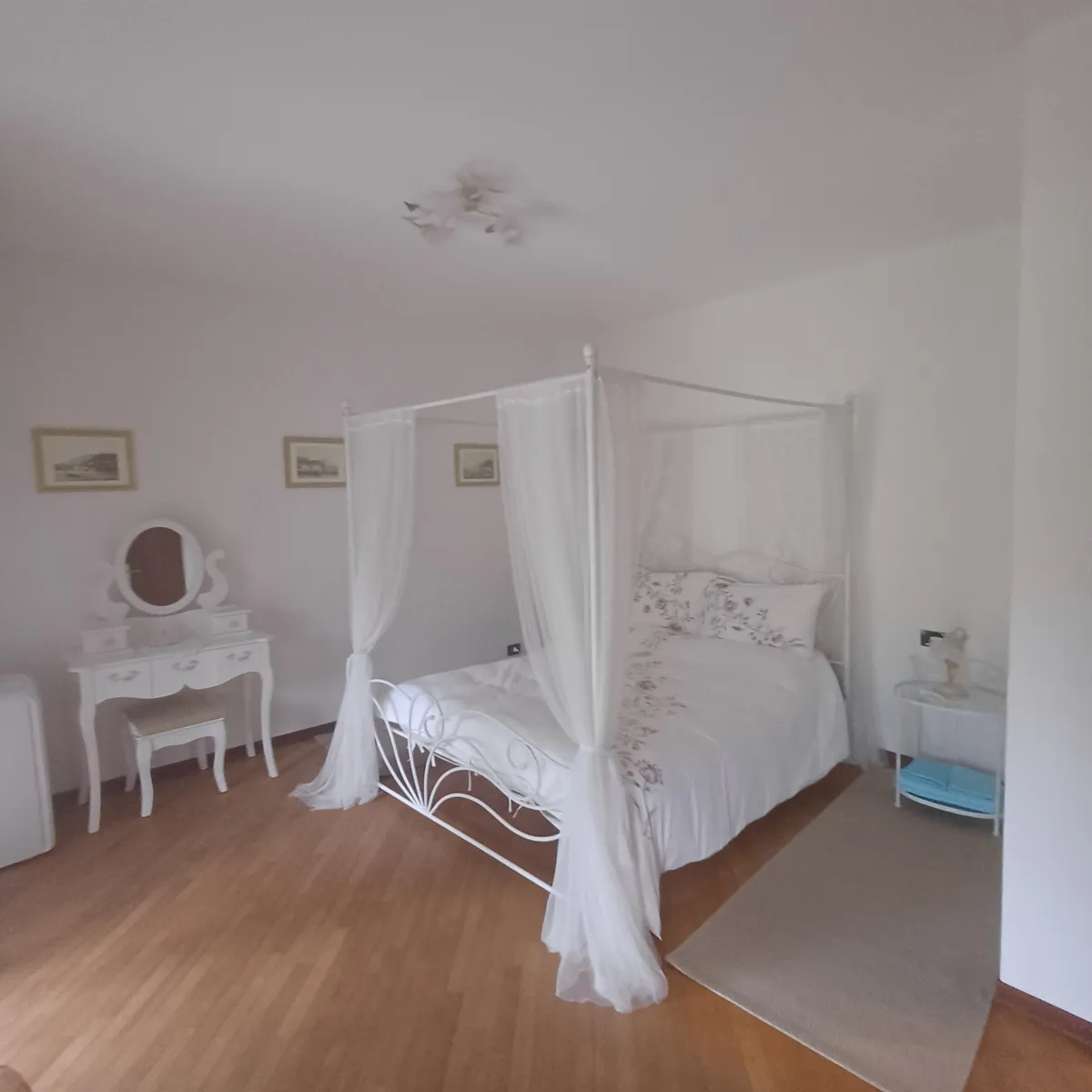La camera con il letto a baldacchino e la toeletta